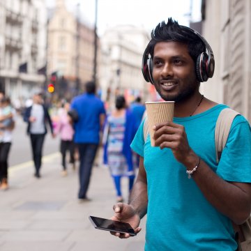 man wireless headphones drinking coffee smartphone blue t shirt